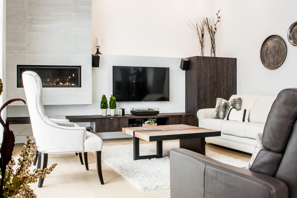 Joli salon moderne avec téléviseur mural, foyer encastré et sofas greige