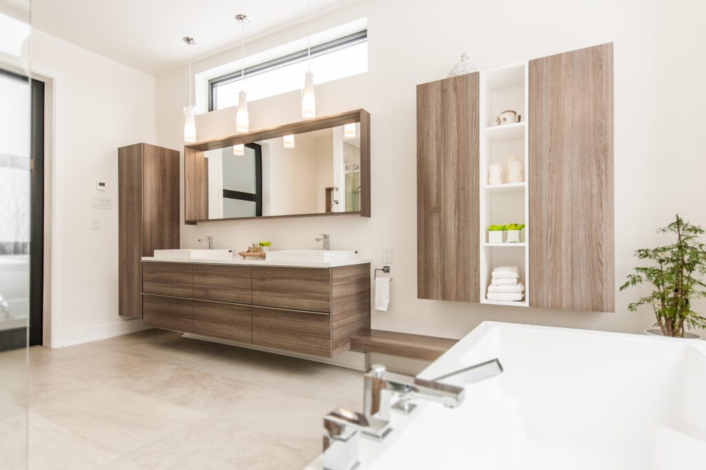 Salle de bain avec armoires en bois couleur noyer et grand miroir