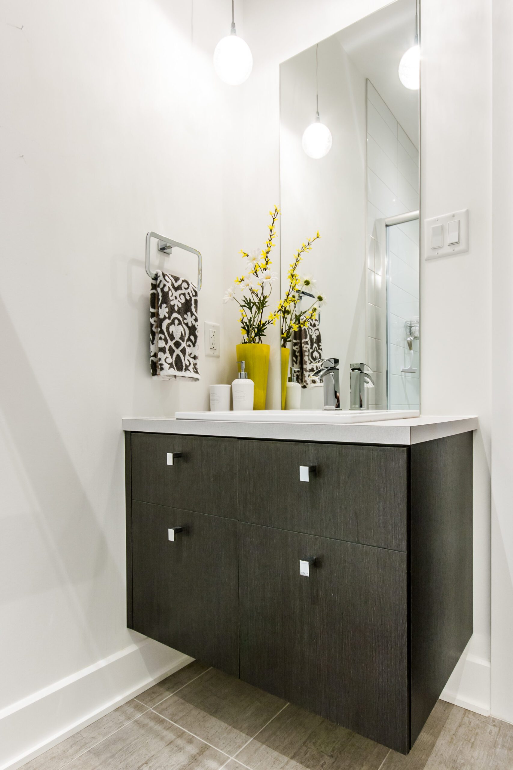 Meuble lavabo en bois foncé avec vase de fleurs jaunes