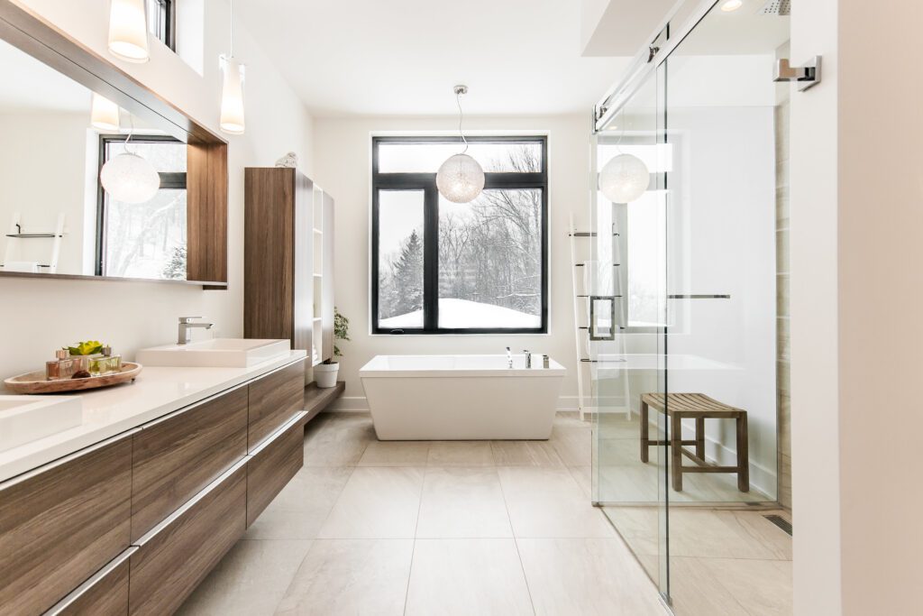 Grande salle de bain moderne avec bain autoportant blanc et grande douche vitrée