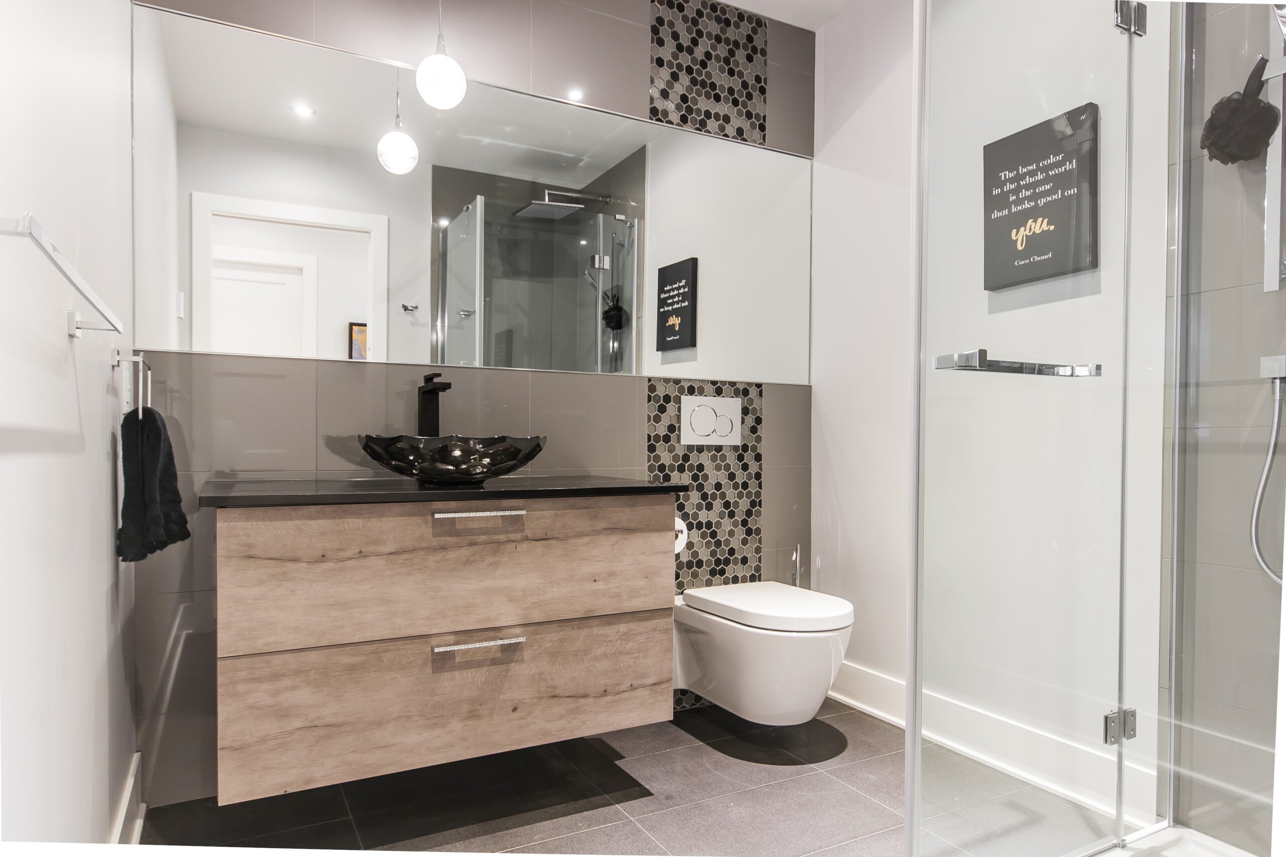 Salle de bain avec douche vitrée et meuble lavabo gris