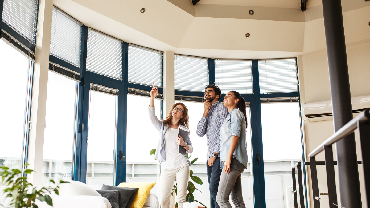 couple qui visite une maison avec agente immobilière