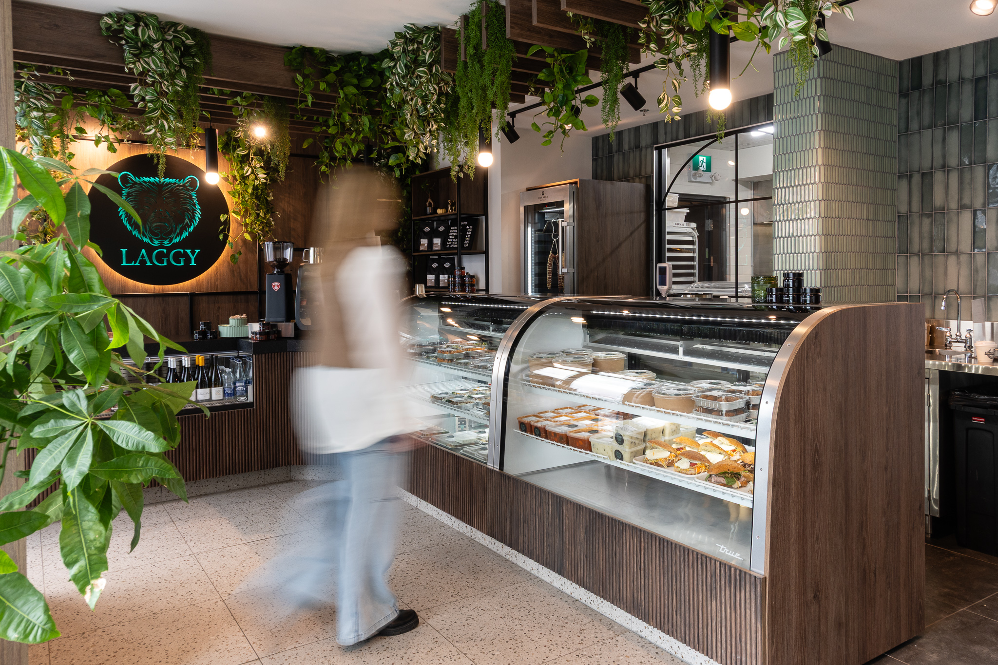 Commerce style bistro avec présentoirs en verre et enseigne lumineuse Laggy. silhouette de femme floue