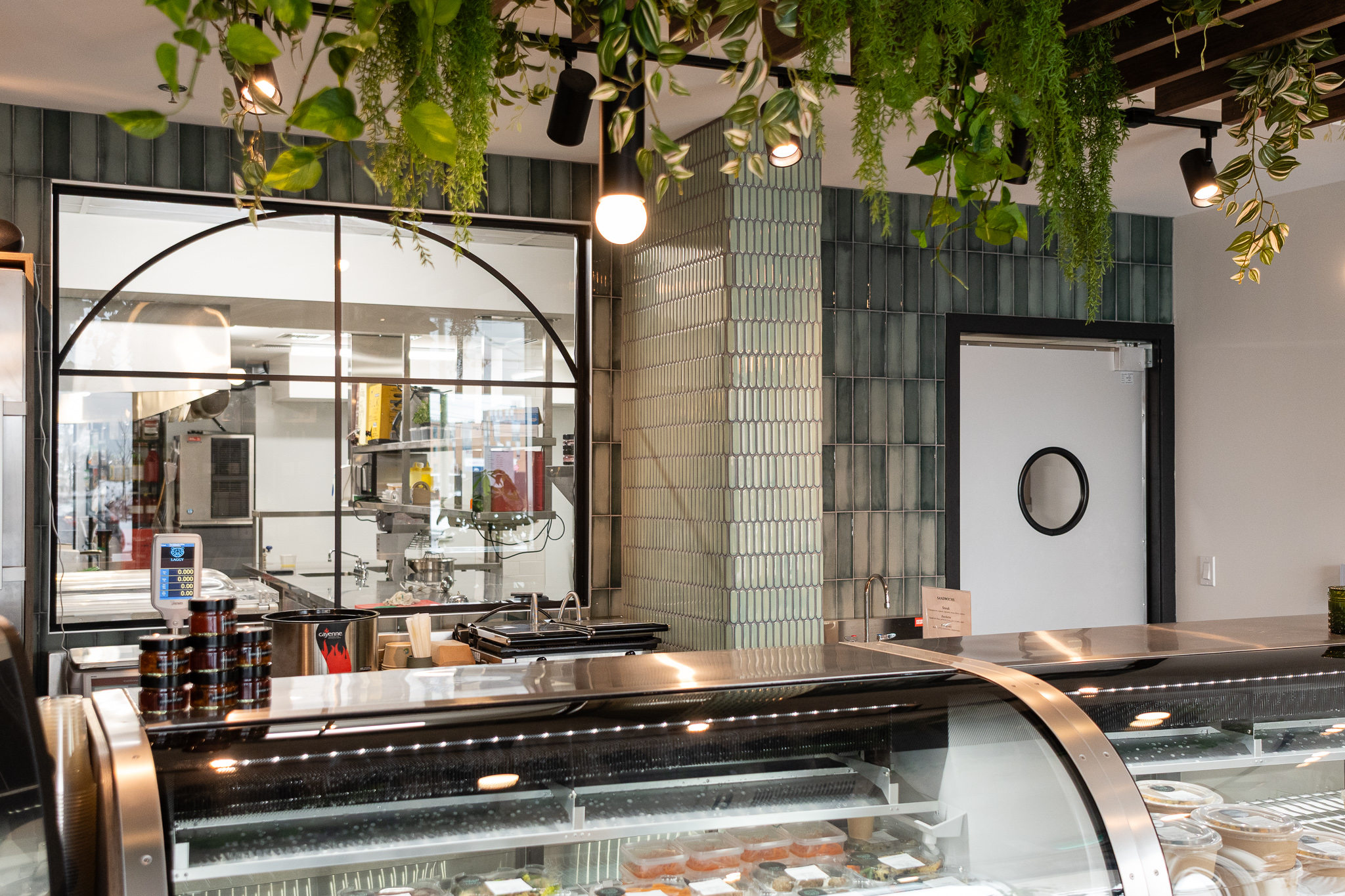 Commerce style bistro avec présentoirs en verre et plantes suspendues