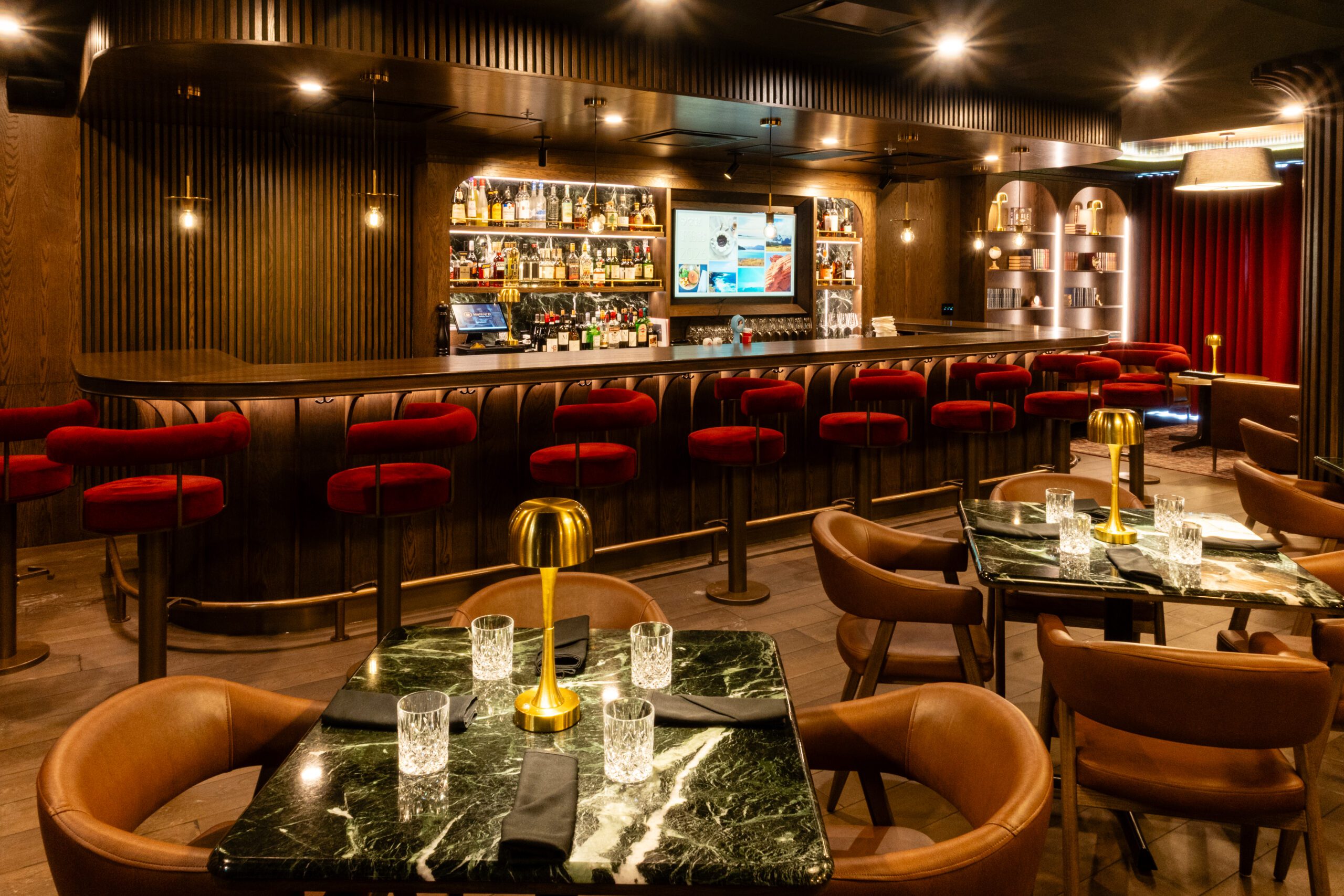 restaurant tamisé moderne avec luminaires, tables et fauteuils en cuir