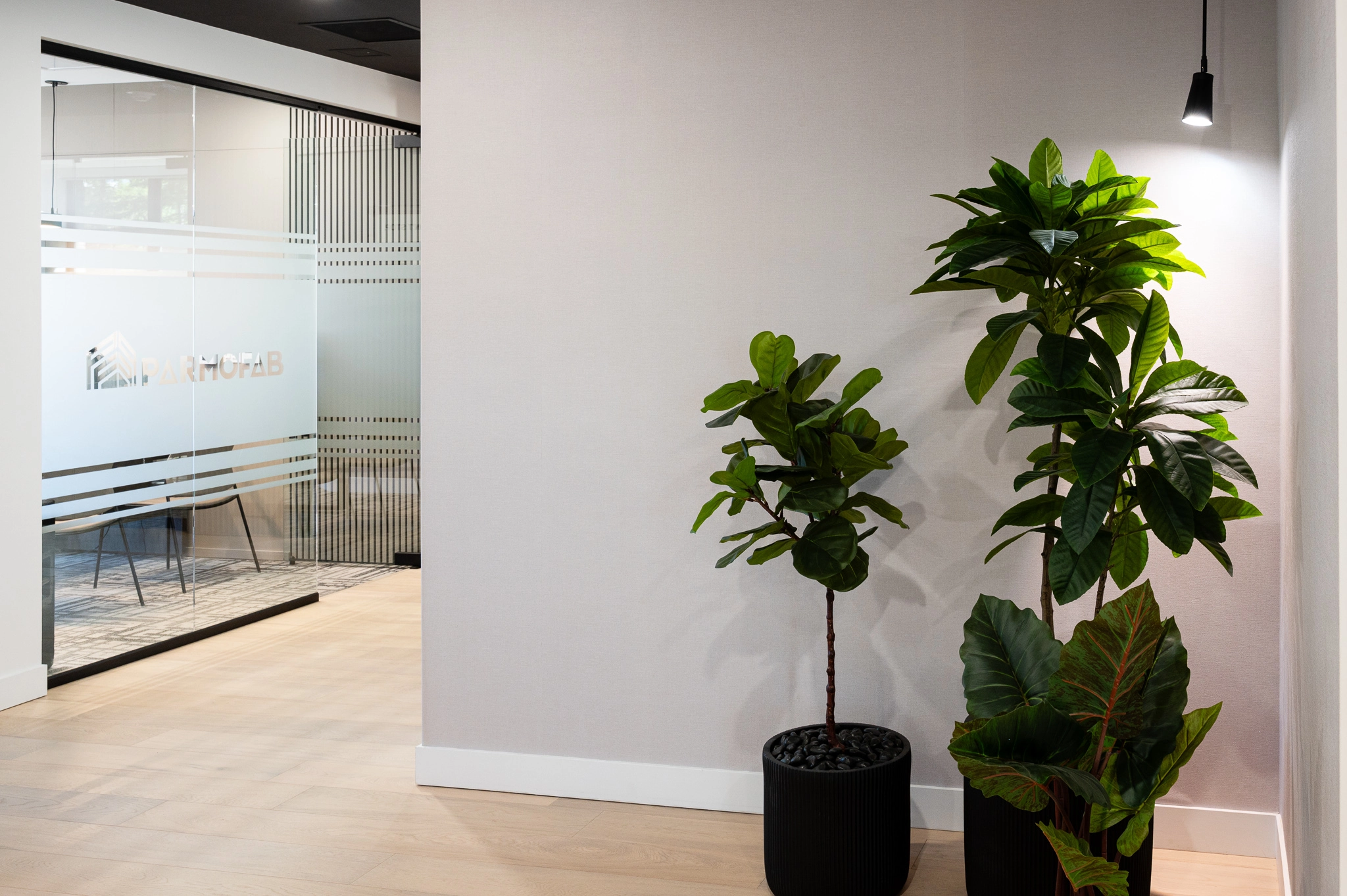Bureau espace professionnel Parmofab avec enseigne blanche vitrée et plante verte.