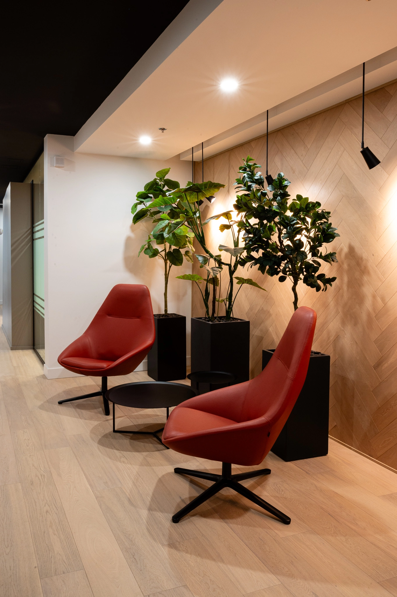 deux fauteuils rouges et table noire au centre, salle d'attente de bureau.